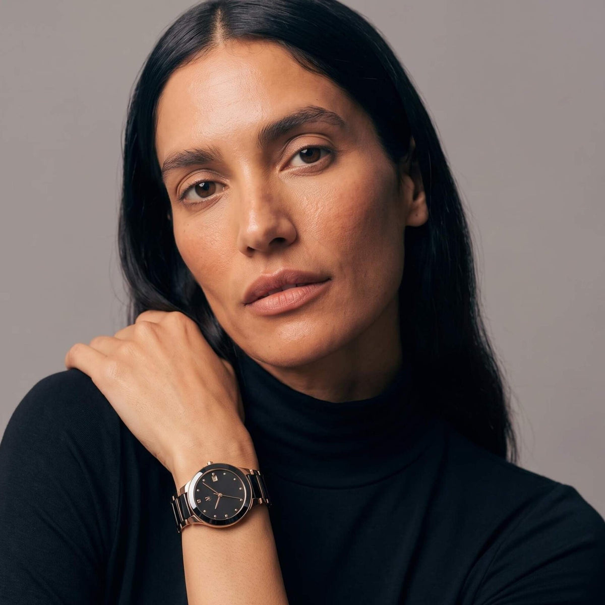 Woman wearing the NCMPRBL Petite Link Miracle black and rose gold watch