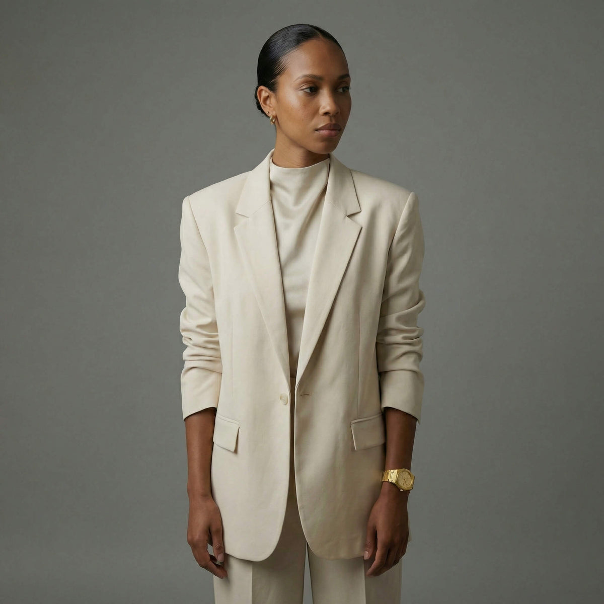 NCMPRBL Ascend Aurel 36MM gold link bracelet watch paired with beige suit, virtual try-on available online