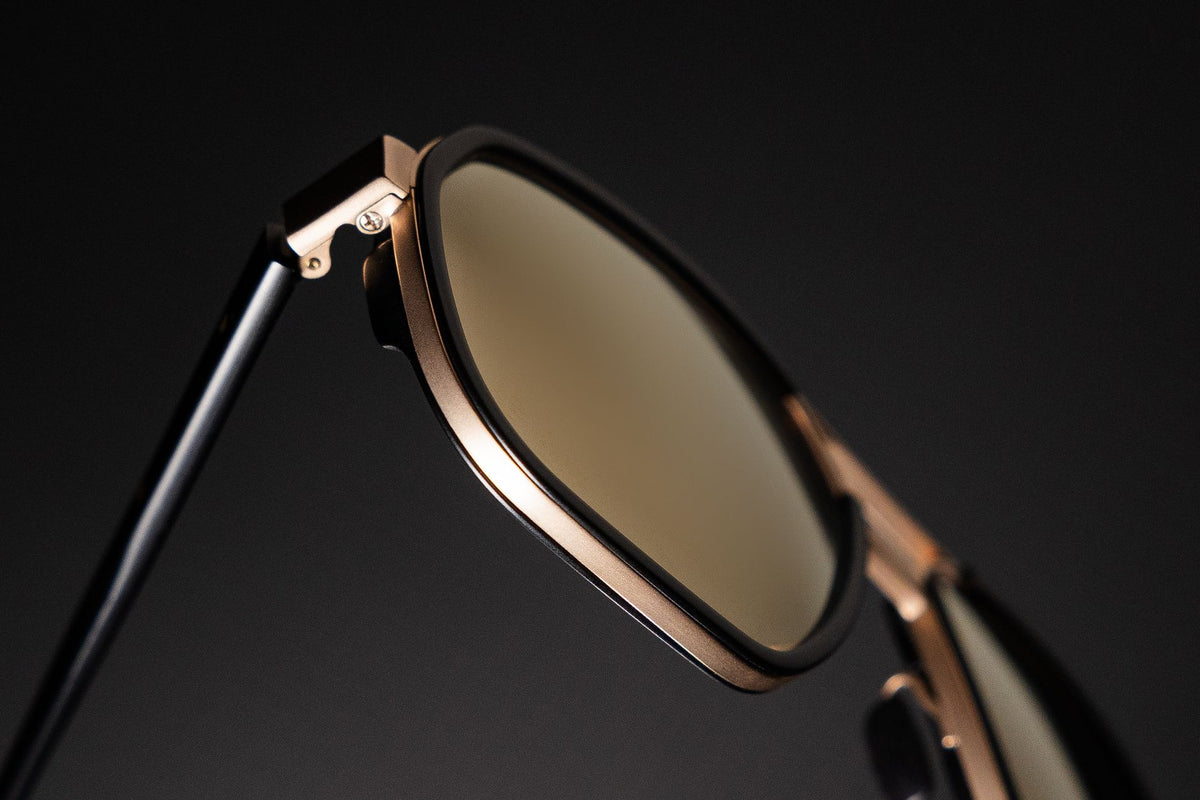 Close-up of stylish modern sunglasses with a sleek metallic frame, showcasing luxury eyewear design.