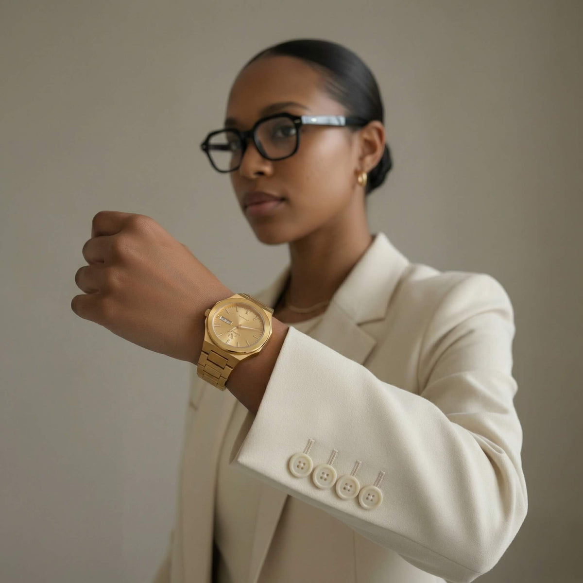 NCMPRBL Ascend Aurel 36MM gold link bracelet watch styled on woman with white blazer, virtual try-on available