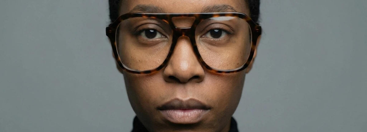 Two models wearing NCMPRBL Axis flat top acetate eyeglasses in a dark studio