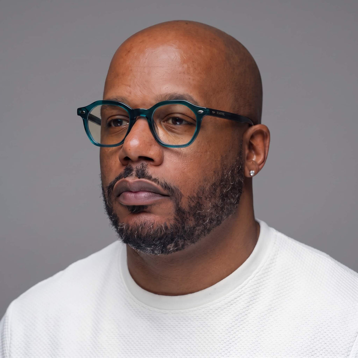 Man wearing NCMPRBL Manifest deep evergreen teal eyeglasses, three-quarter view
